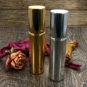 A gold and silver Travel Perfume Bottle that is a Refillable Perfume Atomizer. These Pocket Perfume Spray bottles can go anywhere with you as you travel. These sleek Atomizer Bottles make the perfect Luxury Travel Spray.
