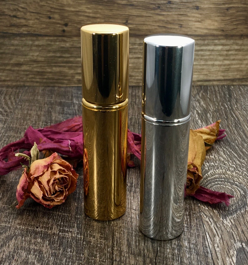 A gold and silver Travel Perfume Bottle that is a Refillable Perfume Atomizer. These Pocket Perfume Spray bottles can go anywhere with you as you travel. These sleek Atomizer Bottles make the perfect Luxury Travel Spray.