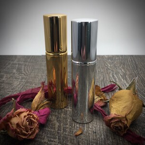 Gold and Silver 12 ml Essential Oil Bottle can also hold Perfume Oils, Fragrance oils and Colognes. Roses are by the bottles for an showcasing an elegant and luxury perfume bottle look. Include your favorite Rose perfume in your bottle! too!