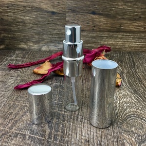All silver perfume travel bottle with the outer casing off so you can see the 12 ml clear roll on bottle inside. This allows you to refill your bottle repeatedly! This is a great empty refillable bottle!