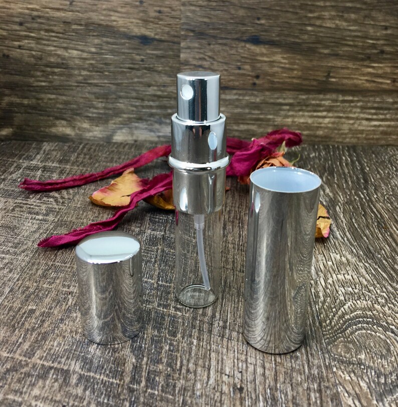 All silver perfume travel bottle with the outer casing off so you can see the 12 ml clear roll on bottle inside. This allows you to refill your bottle repeatedly! This is a great empty refillable bottle!