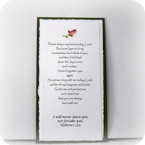 Puede incluir: Una tarjeta blanca con bordes verdes y una flor rosa en la parte superior. La tarjeta tiene un mensaje escrito a mano sobre permanecer en el coraz&oacute;n de alguien y un vers&iacute;culo b&iacute;blico de Hebreos 13:5.
