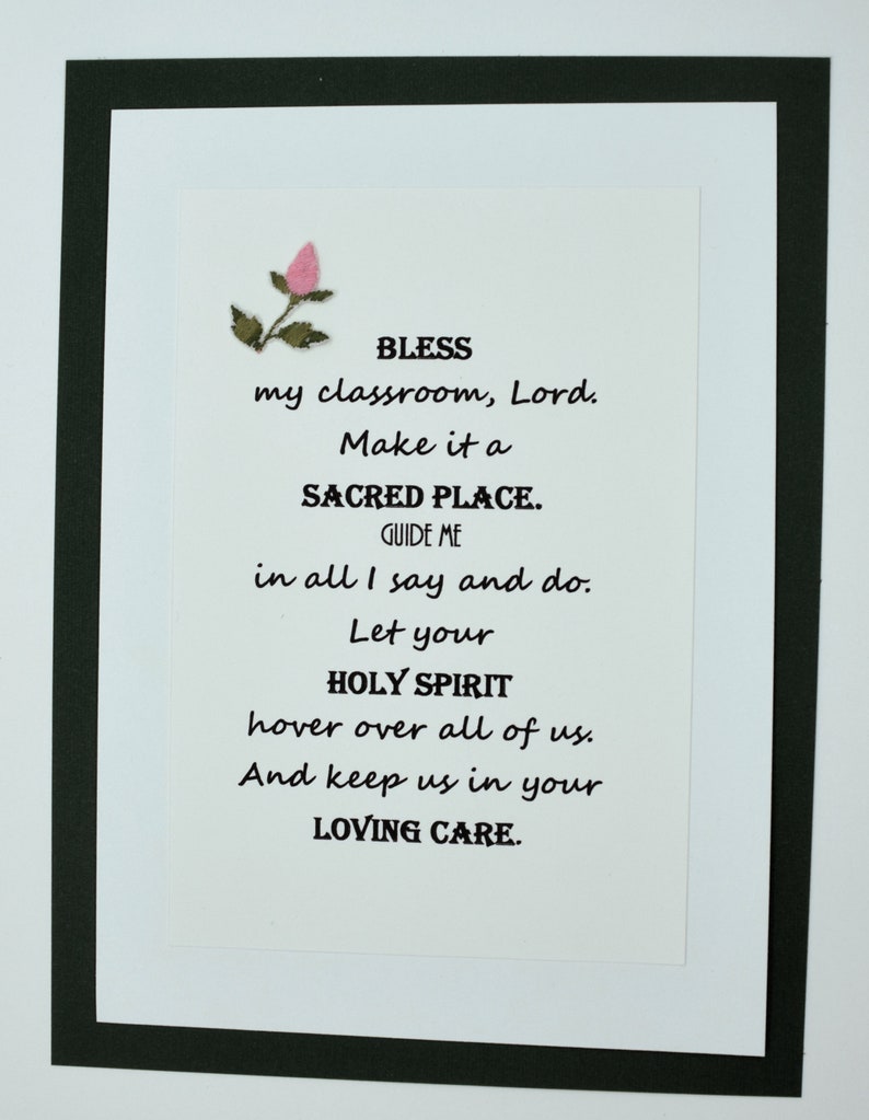 May include: A white card with black text and a pink flower in the top left corner. The text reads: "BLESS my classroom, Lord. Make it a SACRED PLACE. GUIDE ME in all I say and do. Let your HOLY SPIRIT hover over all of us. And keep us in your LOVING CARE."