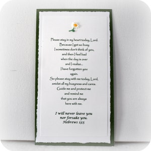 Puede incluir: Una tarjeta blanca con un borde verde y una margarita blanca en la parte superior. La tarjeta tiene un poema sobre permanecer en el coraz&oacute;n de alguien y un vers&iacute;culo b&iacute;blico, Hebreos 13:5.