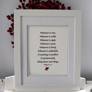 May include: A framed print with a white border. The print features a poem with the text "Whatever is true... Think about such things." The text is in black font. A small red and green floral accent is at the bottom. Red berries are at the top.