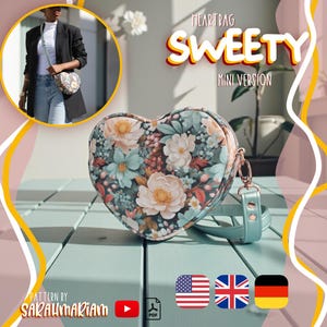Könnte beinhalten: Eine herzförmige Umhängetasche mit Blumenmuster in hellblauen, pfirsichfarbenen und grünen Tönen. Die Tasche hat einen hellblauen Riemen mit Metallbeschlägen. Der Text lautet: HEARTBAG SWEETY MINI VERSION, PATTERN BY SARAUMARIAM.