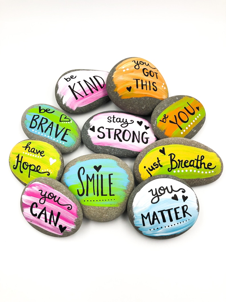 May include: Painted rocks with inspirational messages, including "be kind", "be brave", "stay strong", "you got this", "you can", "smile", "just breathe", "you matter", "have hope", and "be you".