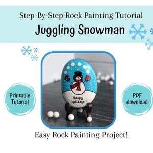 May include: A step-by-step rock painting tutorial for a juggling snowman. The painted rock is blue with white dots and features a snowman with a red scarf and hat. The text "Happy Holidays!" is written on the rock.