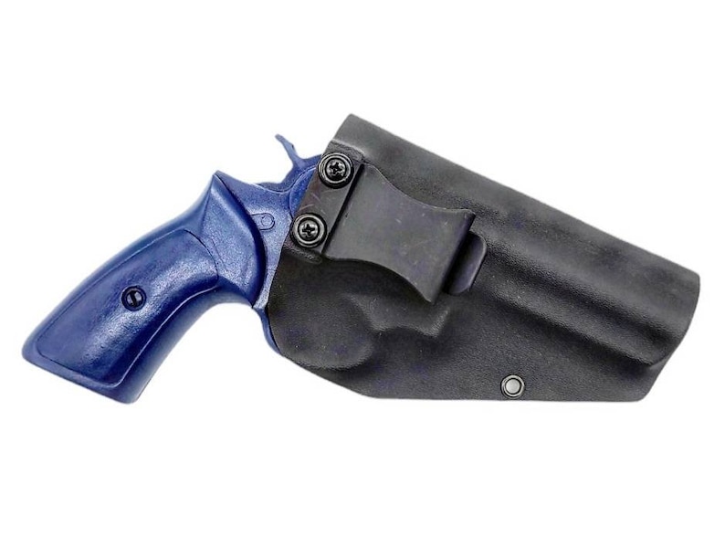May include: A black leather holster with a blue handgun inside. The holster has a metal clip for attaching to a belt.