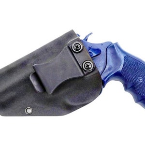 Puede incluir: Una funda de cuero negra con un clip para un revólver azul.