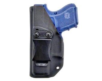 Puede incluir: Una funda negra moldeada con un clip de cinturón resistente asegurado por dos tornillos, que sostiene una pistola azul con empuñadura texturizada. La funda está contorneada a la forma del arma, proporcionando un ajuste seguro para el armazón.