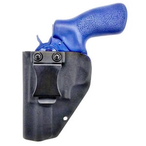 May include: A blue revolver with a textured grip is partially inserted into a black moulded holster. The holster features a black metal belt clip secured by two screws on the front, and a single circular eyelet near the bottom edge.