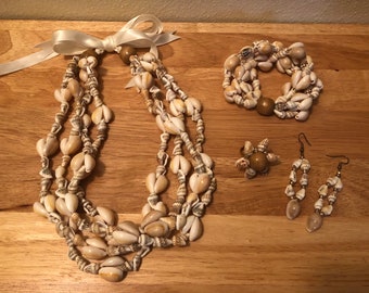 Könnte beinhalten: Ein Set aus Muschelschmuck, bestehend aus einer Halskette, einem Armband, einem Ring und Ohrringen. Der Schmuck ist aus natürlichen Muscheln in Weiß- und Brauntönen gefertigt.