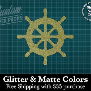 May include: A gold glitter paper ship's wheel prop against a teal grid background. The text "Custom PAPER PROPS" is at the top left. The text "Glitter & Matte Colors" is at the bottom, with "Ships Next Day" in a circle at the top right.
