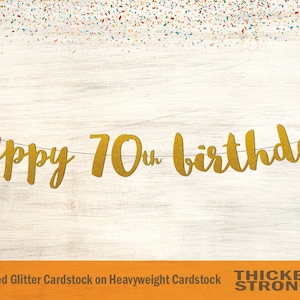 Peut inclure: Banni&egrave;re de joyeux 70e anniversaire en paillettes dor&eacute;es sur fond de bois. La banni&egrave;re est faite de papier cartonn&eacute; paillet&eacute; non-effiloch&eacute; sur papier cartonn&eacute; &eacute;pais. Le texte "Thicker & Stronger" est imprim&eacute; en noir en bas de l'image.