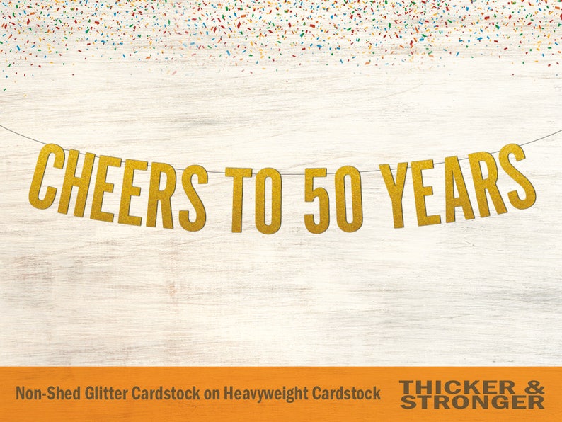 Peut inclure: Banni&egrave;re dor&eacute;e &agrave; paillettes avec le texte "CHEERS TO 50 YEARS". La banni&egrave;re est faite de papier cartonn&eacute; paillet&eacute; non-effiloch&eacute; sur papier cartonn&eacute; &eacute;pais. Le texte "THICKER & STRONGER" est imprim&eacute; en noir sur fond orange.