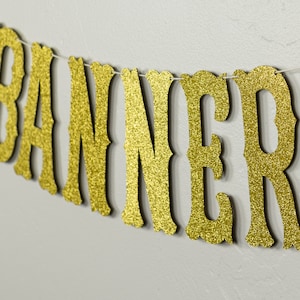 May include: Gold glitter banner with the word "BANNER" in a decorative font.