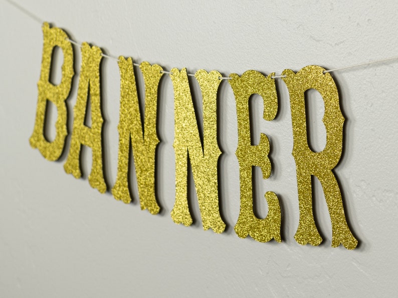 May include: Gold glitter banner with the word "BANNER" in a decorative font.