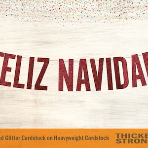 May include: Red glitter banner with the text "FELIZ NAVIDAD" hanging on a white wood background. The banner is made of non-shed glitter cardstock on heavyweight cardstock.