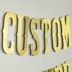 May include: Gold glitter banner with the word "CUSTOM" in a decorative font.