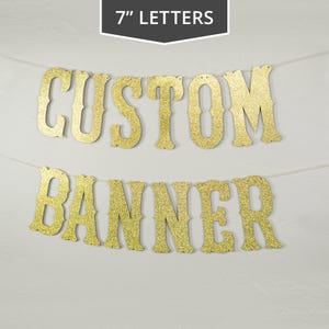 May include: Gold glitter banner with the words "CUSTOM BANNER" in 7 inch letters.