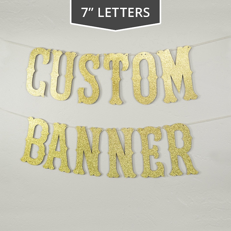 May include: Gold glitter banner with the words "CUSTOM BANNER" in 7 inch letters.