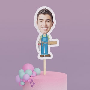 May include: A cake topper featuring a cartoon illustration of a person wearing blue overalls and holding a saw and a piece of wood. The person's face is replaced with a photo of a smiling man.