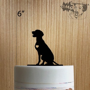 May include: A black silhouette of a dog with a heart cutout on its chest, sitting on a base. The dog is approximately 6 inches tall. The background is a light wood grain.