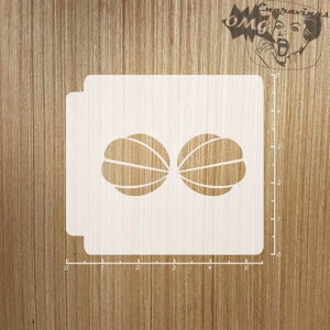 Puede incluir: Un esténcil blanco con un diseño de dos mitades estilizadas de una fruta, posiblemente un melón o una naranja. El esténcil está sobre una superficie de madera, con una regla a un lado. La esquina superior derecha tiene un logotipo con el texto "OMG engravings".