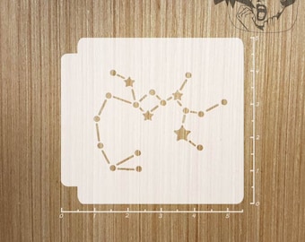 May include: White stencil of the Sagittarius constellation with stars and dots. The stencil is 5 inches wide and 4 inches tall.