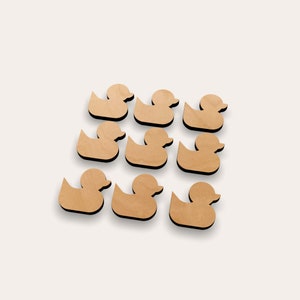 May include: A set of ten wooden duck silhouettes in a light brown color. The ducks are arranged in two rows of five, with the ducks in the back row slightly higher than the ducks in the front row.