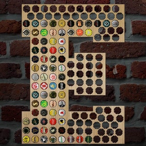 May include: Wooden letter "E" filled with colorful bottle caps, mounted on a brick wall. The letter is made of light-colored wood and has circular cutouts. The bottle caps are of various brands and colors.