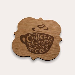 May include: Wooden coaster with a decorative edge. The coaster features a coffee cup design with the phrase "Coffee is always a good idea" etched into the wood. The coaster is brown.