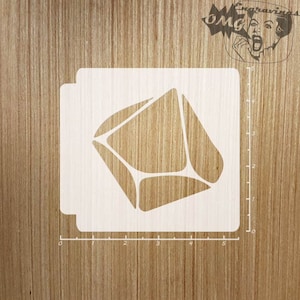 May include: White square stencil with a geometric design, possibly an envelope or gem. A ruler is visible along the side. The background is a light wood grain. The stencil measures approximately 12.7 cm.
