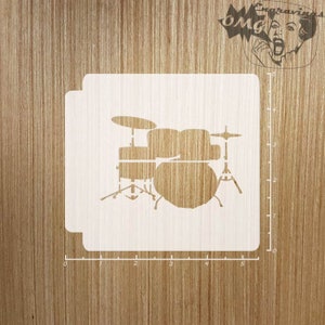 May include: A white stencil of a drum set with a bass drum, snare drum, and two toms. The stencil is on a wooden background.