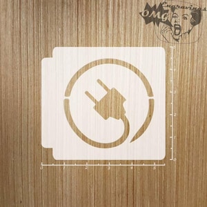 May include: White stencil of an electrical plug inside a circle. The stencil is on a wooden surface.