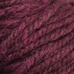 May include: Close-up of a deep purple yarn with a fuzzy texture.