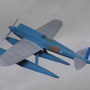 May include: A blue and silver model airplane with a propeller and floats. The airplane has a French flag on the tail and the number "4" on the side.