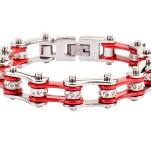 May include: A red and silver chain link bracelet with clear rhinestones. The bracelet is made of metal and has a polished finish.