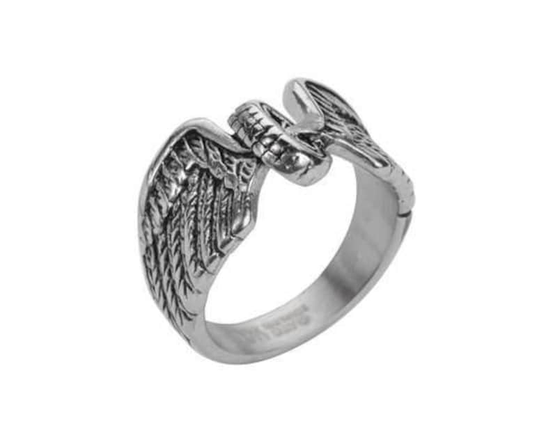 May include: A silver ring with a detailed eagle wing design. The wings are spread out and the eagle's head is facing forward.