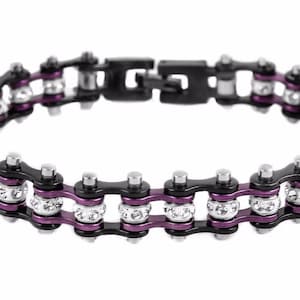 May include: A black and purple motorcycle chain bracelet with clear rhinestones.