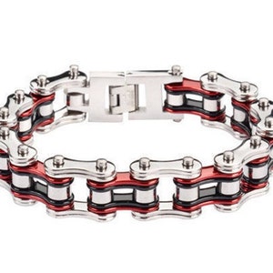 May include: A silver and red chain link bracelet. The bracelet is made of metal and has a black accent.