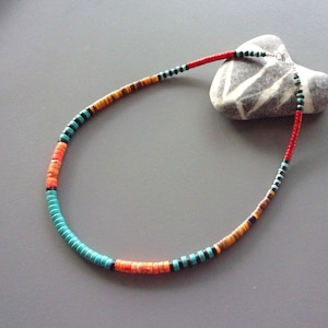 Peut inclure: Un collier de perles turquoise, orange et marron avec un fermoir argenté.