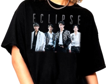Könnte beinhalten: Schwarzes T-Shirt mit einem Grafikdruck einer Band namens "ECLIPSE". Die Bandmitglieder tragen weiße und schwarze Outfits und stehen in einer Reihe.
