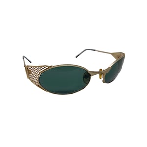 May include: Gold-tone oval sunglasses with a mesh detail on the side arms and green lenses.
