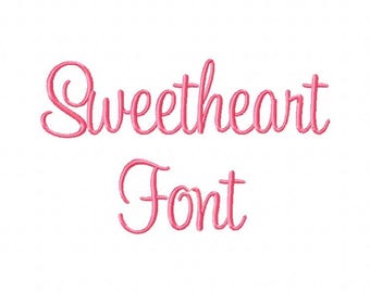 May include: Sweetheart Font, a cursive font with a delicate, feminine style. The word "Sweetheart" is written in the font, followed by the word "Font" in a smaller size.