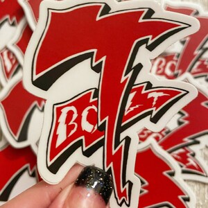 K&ouml;nnte beinhalten: Roter und schwarzer Aufkleber mit einem Blitz-Design und dem Wort "BOLT" in wei&szlig;en Buchstaben.