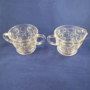 以下が含まれることがあります： テクスチャ加工された隆起したパターンが施された、透明なガラス製の砂糖とクリームのボウル2個セット。ボウルにはそれぞれ2つのハンドルが付いています。