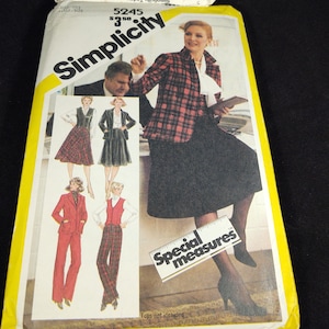 Può includere: Modello di cucito Simplicity numero 5245 per una gonna e pantaloni. Il modello include misure speciali ed è per mezze taglie. La copertina del modello presenta una donna che indossa una giacca a quadri rossi e neri e una gonna nera.