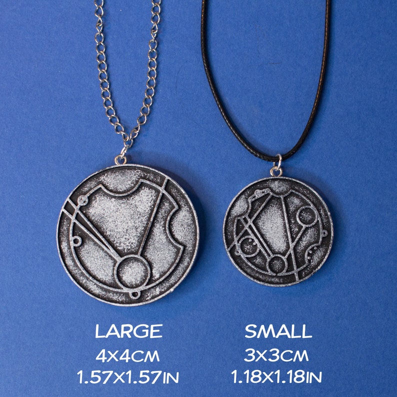 May include: Two silver necklaces with circular pendants featuring a geometric design. The larger pendant measures 4x4 cm and the smaller pendant measures 3x3 cm.
